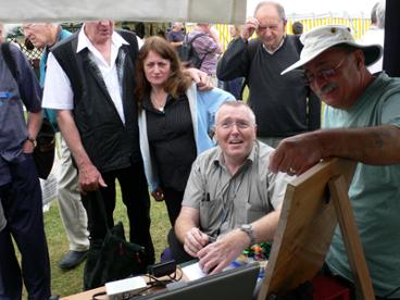 Photograph of Elvaston Castle 2007 FISTS outdoors stand showing a small group of people including Brian G4TDO and John M0CDL.